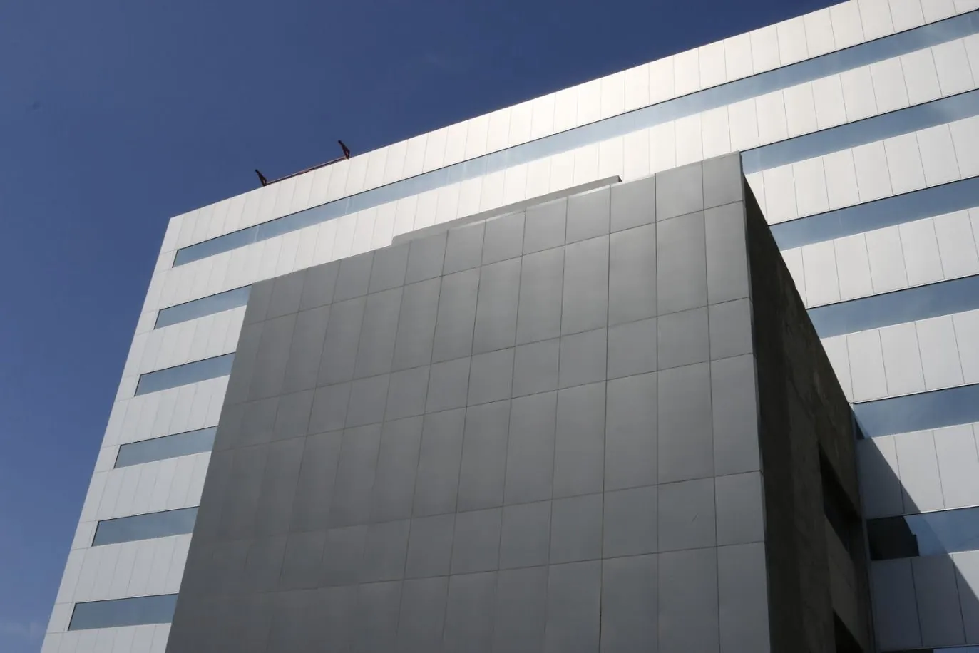 Edificio con franjas en panel Alcopalme gris