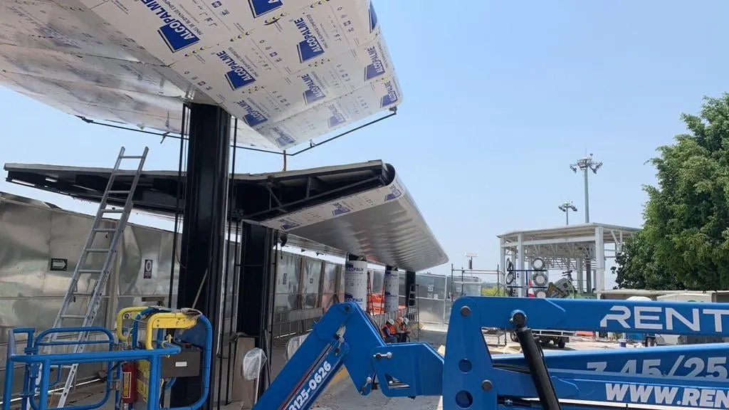 Instalación de panel Alcopalme en obra con plataforma elevadora