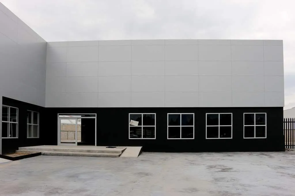 Nave industrial con fachada en panel Alcopalme blanco y negro