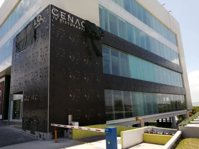 Edificio con celosía perforada en panel Alcopalme negro